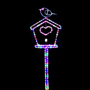 Bird on a lit birdhouse at night